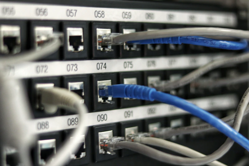 Sala de servidores com racks alinhados e cabeamento organizado